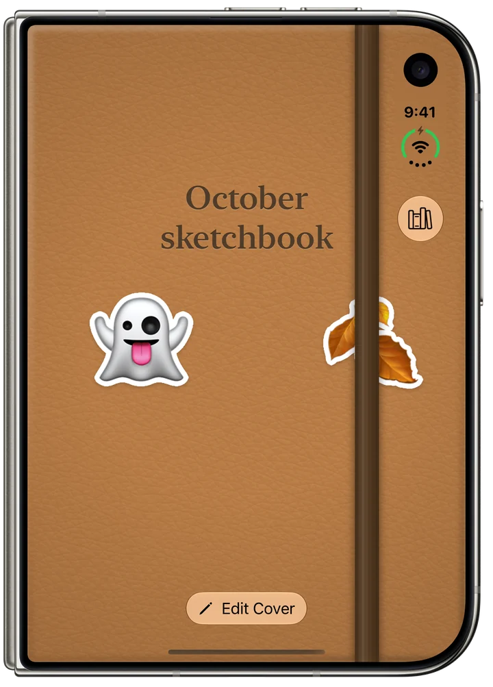 iPhone Duo closed, its outer display showing the notebook's tan leather cover titled “October sketchbook”, with a ghost sticker and a leaf sticker.